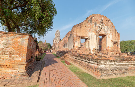 Brick pathway leading through ancient ruins of Wat Ratchaburana temple.