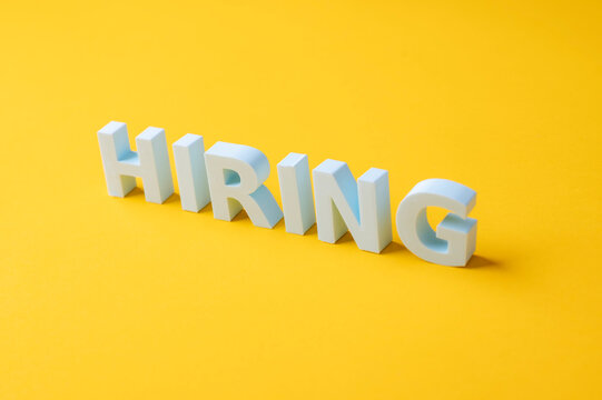 Hiring, recruitment and talent acquisition concept with large white HIRING letters