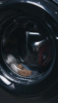 Modern washing machine drum rotating during a laundry cycle, showcasing the cleaning process of clothes inside the appliance, symbolizing household duties and home automation