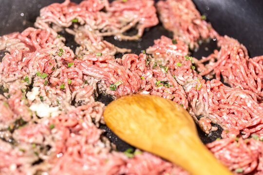 Raw Ground Beef Frying in a Pan with Cooking Oil and Wooden Spoon for Fresh Homemade High Protein Low Carb Meal