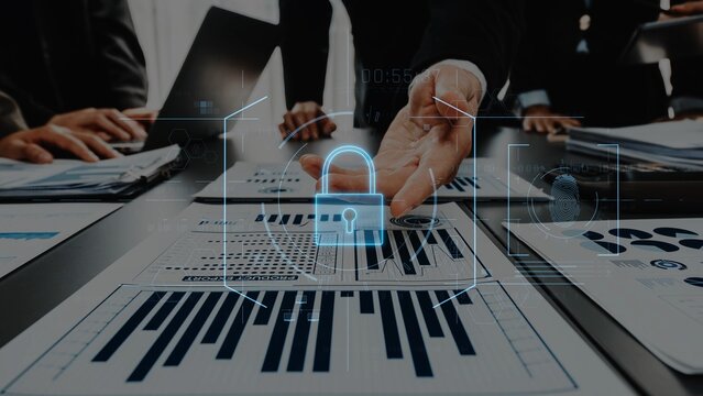 A professional business team collaborates on data analysis while an overlay of a security icon symbolizes the importance of protecting information in a modern office. Raster
