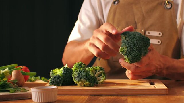 Man chef cooking broccoli, Macro of Broccoli close-up, fresh green broccoli, healthy food, vitamins, raw food and vegetarian lifestyle concept, kitchen vegan food. 