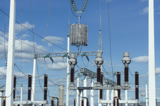 High voltage electric power substation transformer equipment against blue sky. Electrical grid infrastructure, power generation plant, energy supply transmission and distribution concept.