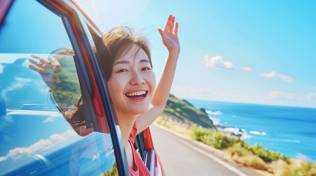 A smiling Japanese woman waving from her car window while driving