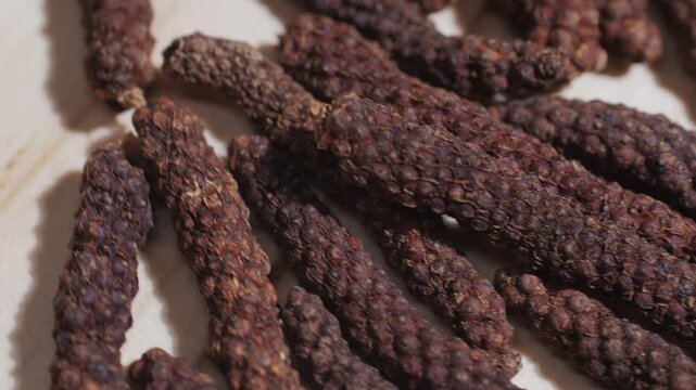Indonesian long black peppercorns, close up of spices, dry hot pepper. 