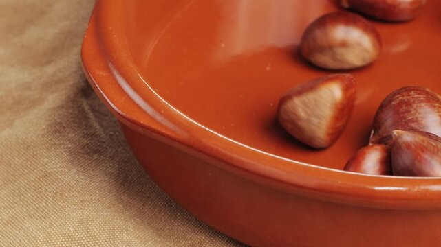 Fresh chestnut, supermarket food, Oven roasted chestnuts with sliced peel on wooden board, spanish traditional winter dish.