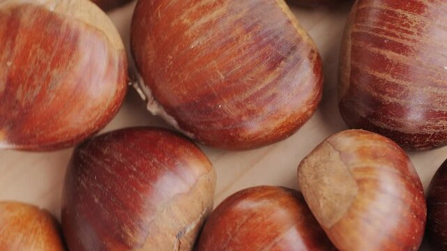 Fresh chestnut, supermarket food, Oven roasted chestnuts with sliced peel on wooden board, spanish traditional winter dish.