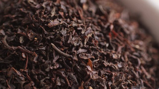 Earl grey close up leaf tea blend with orange blossom petals on dark marble board. Macro indian sri lanka tea.