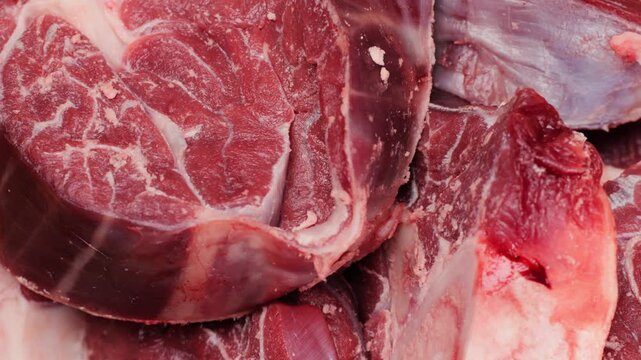 Fresh beef ossobuco steak with salt, spices and herbs on textured background, bones. 