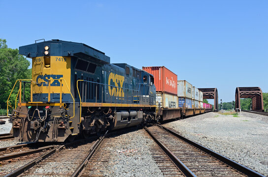 A CSX Transportation locomotive serving as a rear-train distributed power unit helps move a westbound stack train through a double diamond crossing and across a bridge in south suburban Chicago.