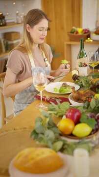 Senior parents and adult daughter enjoy Christmas dinner together at home. Happy family sharing festive holiday meal with roast chicken, salad and wine around dining table during seasonal celebration.