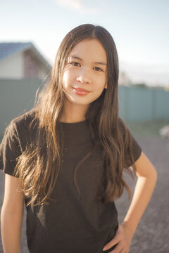 Portrait of healthy and happy mixed Asian preteen girl, natural golden hour light