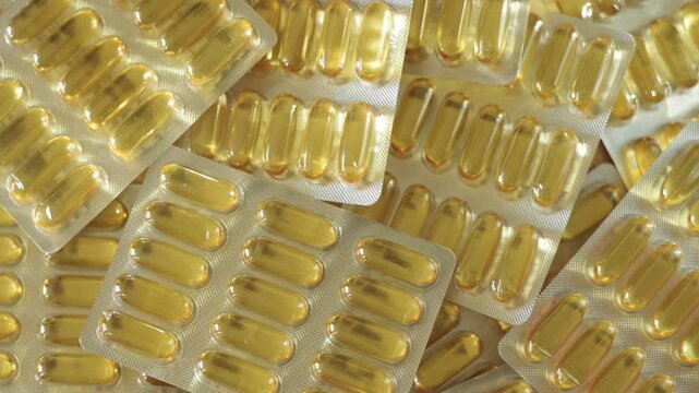 Close-up view of omega-3 capsules displayed in transparent blisters, highlighting their glossy texture and organized layout on a light surface