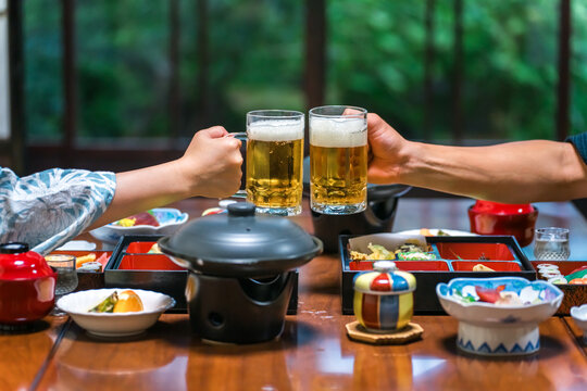 Couple Toasting with Beer at a Japanese Ryokan and Enjoying Kaiseki Cuisine on a Hot Spring Trip