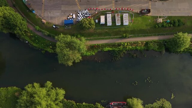 Aerial footage captures the transition from a serene green landscape to an expansive industrial site with silos and factory structures visible