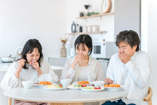 Family of Three Feeling Nauseous During a Meal, Parent and Child Suffering from Food Poisoning
