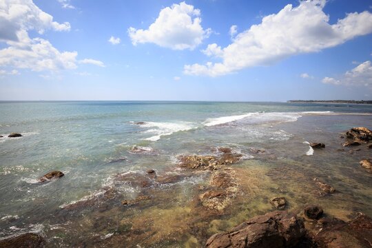 Rugged Rocky Shore and Waves Under a Bright Sky