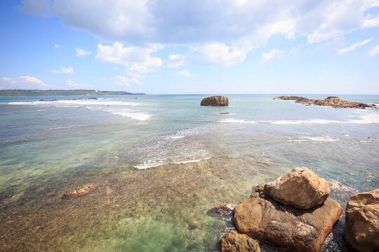 Rugged Rocky Shore and Waves Under a Bright Sky