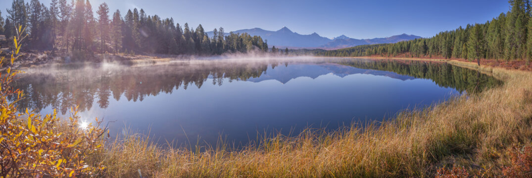 Mountain lake on an autumn morning, sunny weather, forest shores, panoramic view