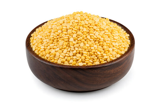 Healthy organic yellow moong dal split peas served in a rustic wooden bowl isolated on a white studio background