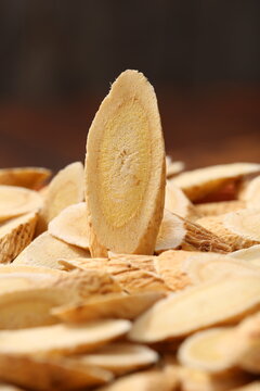 Dried slices of astragalus root in a wooden spoon and basket,traditional Chinese medicine