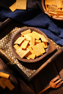 Crispy savory square rice crackers on rustic wooden table