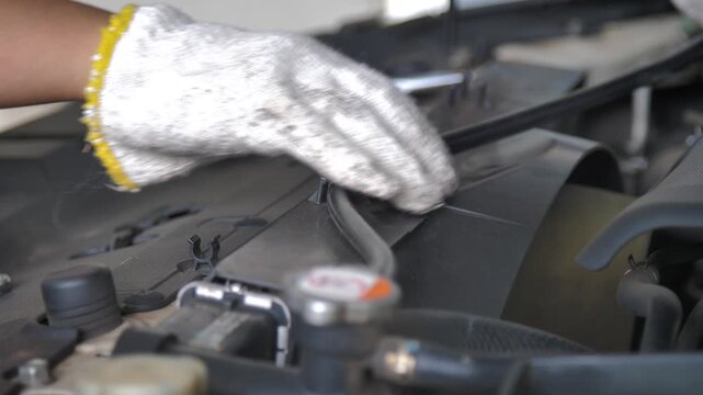 Close up shot hands of the mechanic checking a front car engine 