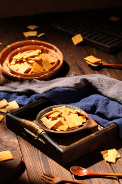 Crispy savory rice crackers on a rustic wooden tray