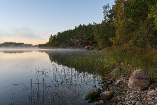 Wooden bathhouse on the shore of Lake Ladoga near the village of Lumivaara on a foggy autumn morning, Ladoga Skerries, Lahdenpohya, Republic of Karelia, Russia