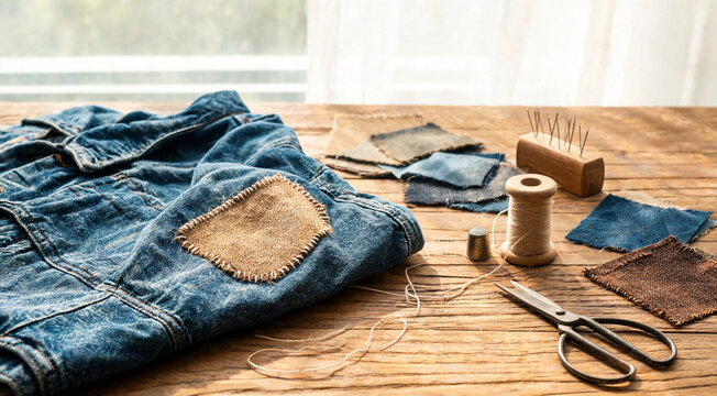Denim patchwork and sewing tools on wooden table.