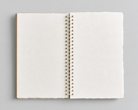 Blank spiral sketchbook open notebook overhead view paper texture white page empty page center binding minimal composition