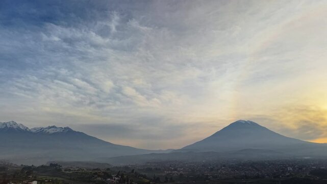 Aerial drone view of the Chachani and Misti volcanoes above the city at dusk, Arequipa, Peru