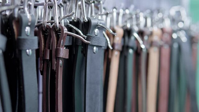 Leather belts with buckles hanging in a store