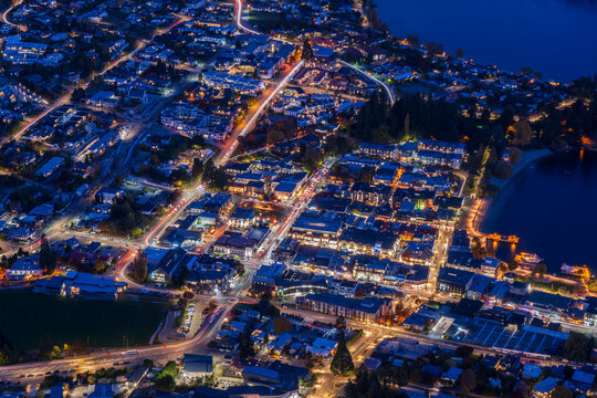 Illuminated town centre and waterfront seen steeply from above at night, Queenstown