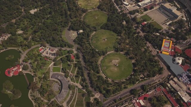 Smooth circular drone flight over C&aacute;rcamos de Dolores and Chapultepec Lake, surrounded by dense vegetation and the urban landscape of Mexico City.