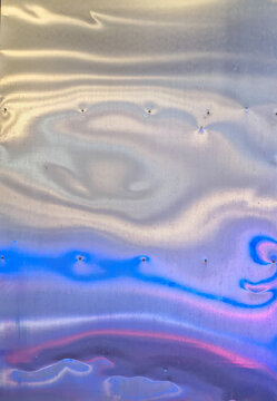 polished metallic sheet with colorful blue and magenta light reflections targeting abstract industrial background design