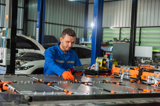 EV technicians inspect engineer inspecting electric vehicle battery