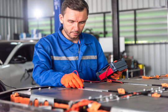 EV technicians inspect engineer inspecting electric vehicle battery