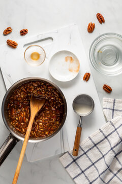 Top down view of a pot of caramel pecan mixture for making pecan pie cookies.