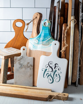 Various cutting boards leaning against a subway tile background.