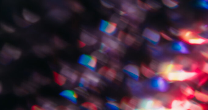 Blur flare. Bokeh shimmer. Defocused purple blue pink bright color illuminated optical neon rainbow dazzle flash on abstract art dark black background.