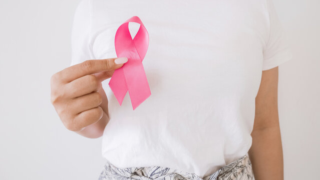 Woman hand holding pink ribbon, Breast cancer awareness and October Pink day, world cancer day
