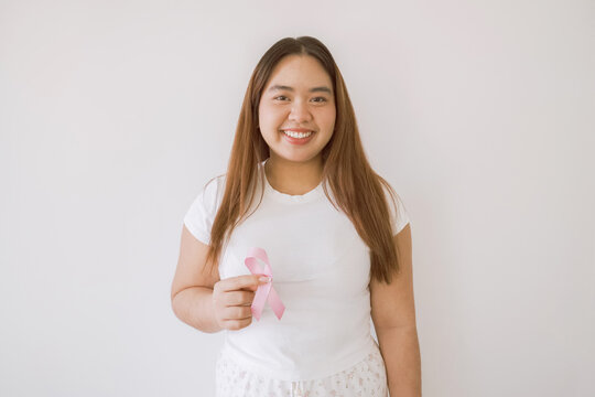 Woman hand holding pink ribbon, Breast cancer awareness and October Pink day, world cancer day