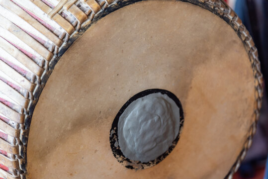 Close up detail of traditional Thai drumhead central tuning paste woven wooden rim showing handmade craftsmanship music culture aged natural texture
