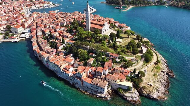 Aerial drone view of the old town peninsula with the church tower, the rocky shore and the turquoise sea, Rovinj, Croatia
