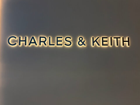 The image displays a close-up of the logo for a contemporary fashion brand, featuring the names 'Charles' and 'Keith' in an elegant, modern font. The letters are illuminated against a neutral backgrou