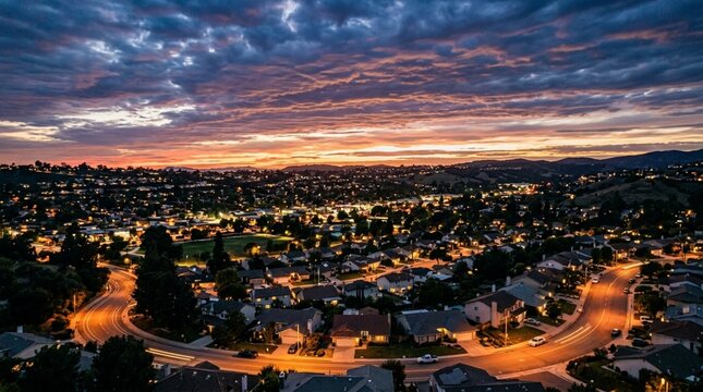Suburban sprawl at dusk with dramatic cloudy sky and glowing streetlights.