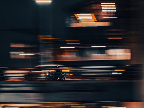 Dynamic Motion Blur of Motorcyclist Riding Under Overpass at Night