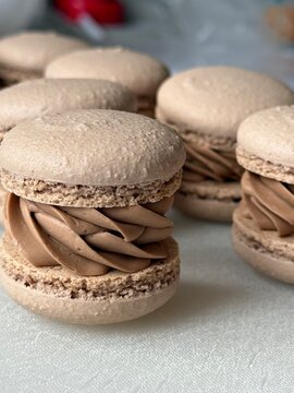 Stack of freshly made chocolate macarons filled with creamy ganache   
