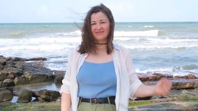 Portrait of young woman against backdrop of sea front view.